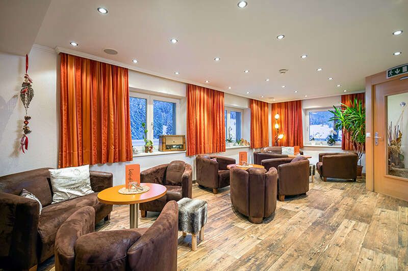 Entrance area and bar with lounge chairs in the Schlossberg